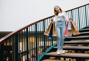 Einkaufen, Glück und Menschen Konzept - - lächelnd stilvoll Teenager Mädchen mit Einkaufen Taschen. Einkaufen Konzept. foto