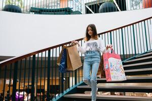 Einkaufen, Glück und Menschen Konzept - - lächelnd stilvoll Teenager Mädchen mit Einkaufen Taschen. Einkaufen Konzept. foto