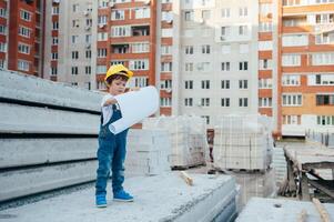 Architekt im Helm Schreiben etwas in der Nähe von Neu Gebäude. wenig süß Junge auf das Gebäude wie ein Architekt foto