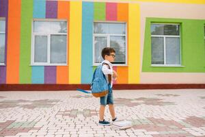 süß Schüler im Weiß Hemden und ein Brille mit Bücher und ein Rucksack. zurück zu Schule foto