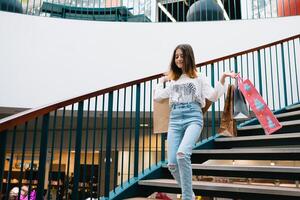 Einkaufen, Glück und Menschen Konzept - - lächelnd stilvoll Teenager Mädchen mit Einkaufen Taschen. Einkaufen Konzept foto