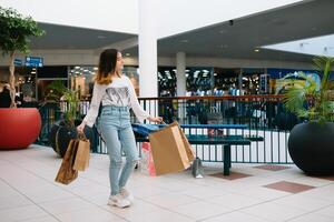 Einkaufen, Glück und Menschen Konzept - - lächelnd stilvoll Teenager Mädchen mit Einkaufen Taschen. Einkaufen Konzept. foto