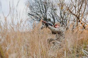 Jagd erlauben. Mann brutal Wildhüter Natur Hintergrund. Jäger verbringen Freizeit Jagd. Jäger halt Gewehre. Fokus und Konzentration von erfahren Jäger. Jagd und fangen Jahreszeiten foto