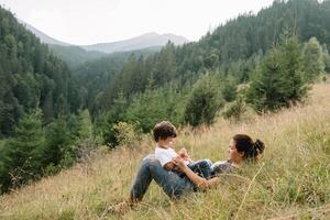 jung Mama mit Baby Junge Reisen. Mutter auf Wandern Abenteuer mit Kind, Familie Ausflug im Berge. National Park. Wanderung mit Kinder. aktiv Sommer- Feiertage. Fischauge Linse. foto