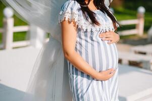 schön schwanger Frau halten Bauch draussen foto