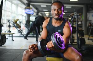 afrikanisch amerikanisch Mann Arbeiten aus im das Fitnessstudio. foto