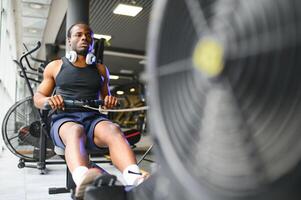 afrikanisch amerikanisch Mann Arbeiten aus im das Fitnessstudio. foto