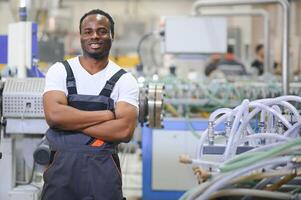 ein Afroamerikaner männlich Arbeiter im ein Plastik Fenster Rahmen Fabrik foto