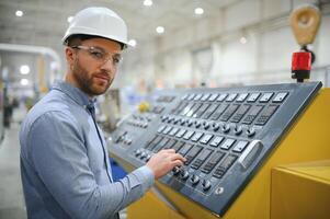 Ingenieur im Helm ist mit ein Laptop im ein schwer Industrie Fabrik foto