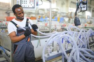 ein Afroamerikaner männlich Arbeiter im ein Plastik Fenster Rahmen Fabrik foto