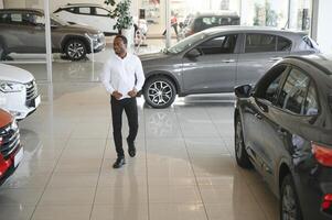 jung afrikanisch amerikanisch Auto Händler Schulleiter Stehen im Fahrzeug Ausstellungsraum foto