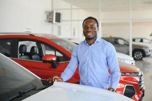 glücklich Auto Käufer, Neu Auto Inhaber Konzept. Porträt von aufgeregt jung afrikanisch amerikanisch Kerl im Händler Ausstellungsraum foto