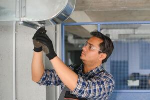 Belüftung Reinigung. Spezialist beim arbeiten. Reparatur Belüftung System HVAC. industriell Hintergrund foto