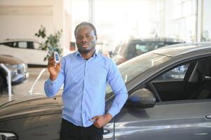 glücklich lächelnd Mann halten Auto Schlüssel Angebot Neu Auto auf Hintergrund foto