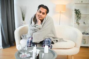 krank jung Hindu Mann Gefühl Schlecht im das Morgen, Sitzung auf Bett foto