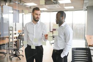 Kollegen diskutieren und Stock Anmerkungen auf das Glas foto