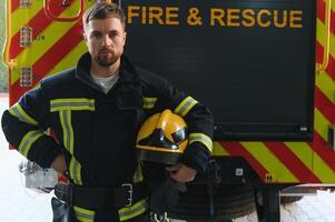 Feuerwehrmann im Uniform und Helm in der Nähe von Feuer Motor foto