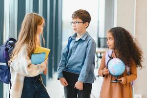 Porträt von lächelnd wenig Schule Kinder im Schule Gang foto