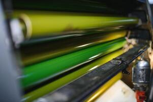 Grün Tinte auf Walzen von industriell Versatz Drucker während Arbeit im Typografie Werkstatt foto