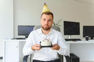 traurig jung Geschäftsmann feiern Geburtstag allein im Büro foto