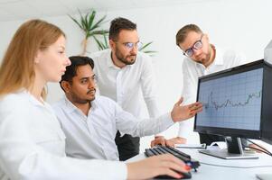 Team bei der Arbeit. Gruppe junger Geschäftsleute in eleganter Freizeitkleidung, die im Kreativbüro zusammenarbeiten foto