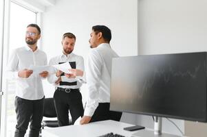 Team bei der Arbeit. Gruppe junger Geschäftsleute in eleganter Freizeitkleidung, die im Kreativbüro zusammenarbeiten foto