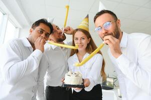 glücklich Geschäftsfrau halten Geburtstag Kuchen während Herstellung Überraschung Party mit ihr Kollegen im das Büro. foto