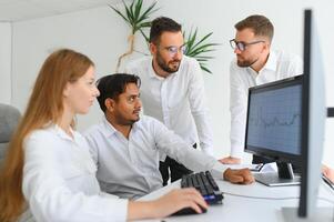 glücklich Geschäftsleute Lachen während zusammenarbeiten auf ein Neu Projekt im ein Büro. Gruppe von vielfältig Geschäftsleute Arbeiten zusammen im ein modern Arbeitsplatz foto