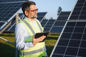 Senior männlich Ingenieur inspiziert Solar- Paneele auf Bauernhof. sauber Energie. foto