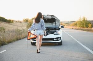 jung Frau in der Nähe von gebrochen Auto im Landschaft. foto