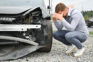 Auto Unfall. Mann nach Auto Unfall. Mann bedauert Beschädigung verursacht während Auto Wrack foto