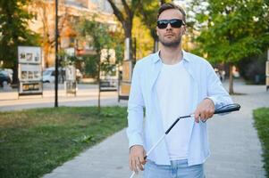 blind Mann. visuell beeinträchtigte Mann mit Gehen Stock, foto