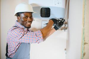 Fachmann Ingenieur Installation ein natürlich Gas Kessel beim heim, er ist Überprüfung das Rohre foto