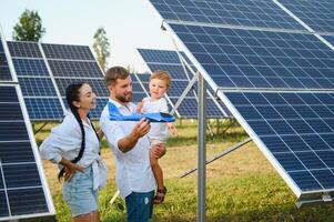 glücklich jung Familie in der Nähe von Solar- Tafeln. Solar- Energie. foto