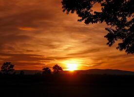 spektakulär Sonnenuntergang über, Orange Sonne steigend oben Über das Horizont foto