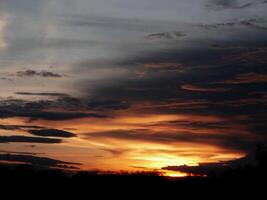 spektakulär Sonnenuntergang über, Orange Sonne steigend oben Über das Horizont foto