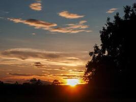 spektakulär Sonnenuntergang über, Orange Sonne steigend oben Über das Horizont foto