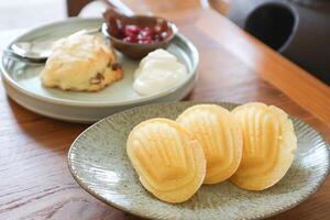 Madeleine oder Madeleines und scone , Cranberry scone oder scone mit ausgepeitscht Sahne und Beere Soße foto