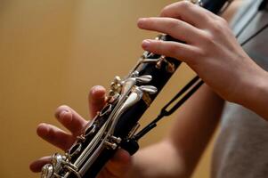 schließen oben von Kinder- Hände spielen das Klarinette im ein Musik- Studio foto