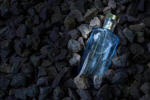 Parfüm Blau transparent Flasche im Kies oder Koralle Hintergrund foto