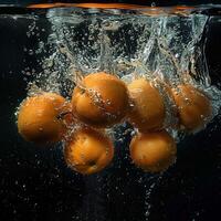 Orangen fallen im Wasser mit Spritzen auf schwarz Hintergrund. foto