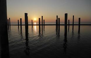 Sonnenuntergang im das Pole Dorf von petten im das Niederlande foto