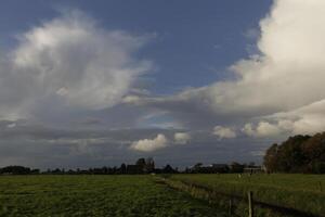 dramatisch Himmel mit Donner Wolken im ein Niederländisch Landschaft foto