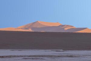 Panorama- Bild von das rot Dünen von das namib Wüste im Namibia gegen ein Blau Himmel im das Abend Licht foto