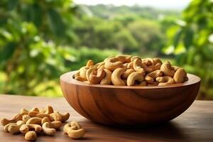 Cashew Nüsse im das hölzern Schüssel mit Garten Hintergrund.. foto