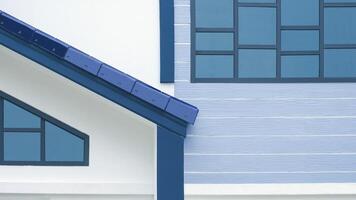 Licht Betrachtung auf Glas Dachboden Fenster Oberfläche mit Teil von Markise Fliese Dach draußen von modern Weiß und Blau Haus Gebäude foto
