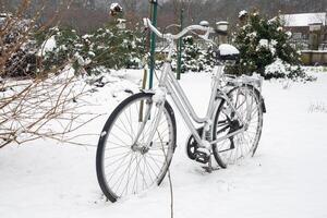 Fahrrad Vergessene im das Hof bedeckt mit Weiß frisch Schnee, Winter Szene foto