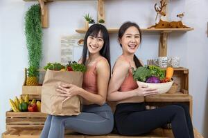 asiatisch Schwester ist haben ein gesund Essen und trinken während Portion jeder andere Kochen im Küche zum vegan, Vegetarier und Pflanze basierend Zutaten foto