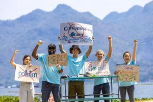 Mannschaft von Ökologe Freiwillige sind demonstrieren Rallye beim Ozean zum Klima Veränderung und Speichern Natur mit Protest Zeichen gegen Verschmutzung und Meer Kontamination zum Tierwelt und Biodiversität foto