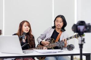 asiatisch Musiker durchführen Felsen Show Leben beim Zuhause mit online Plattform zum Ventilator und Publikum beim Zuhause Konzert und Streaming Übertragung Netzwerk foto